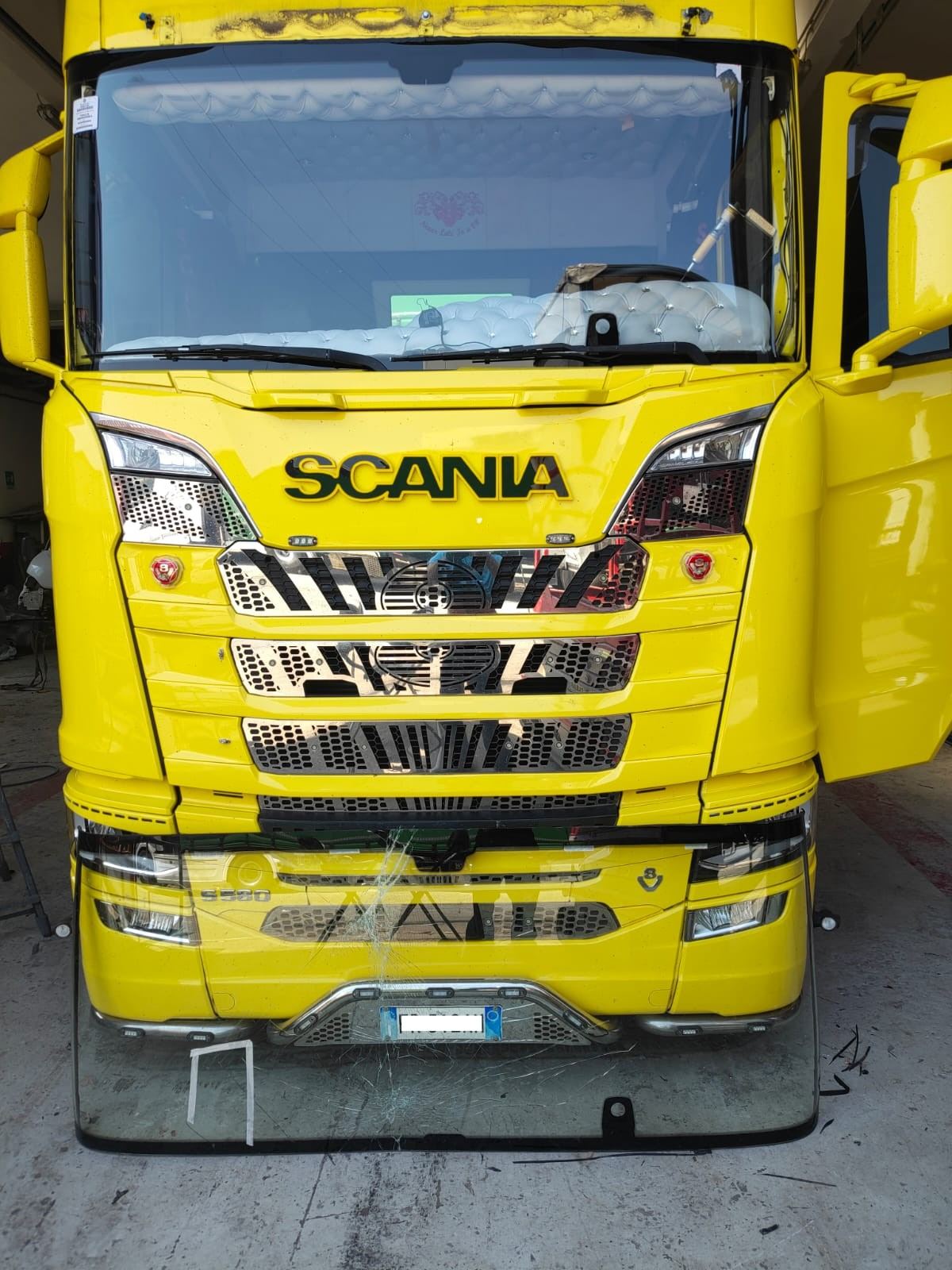 Camion Scania giallo con parabrezza rotto davanti